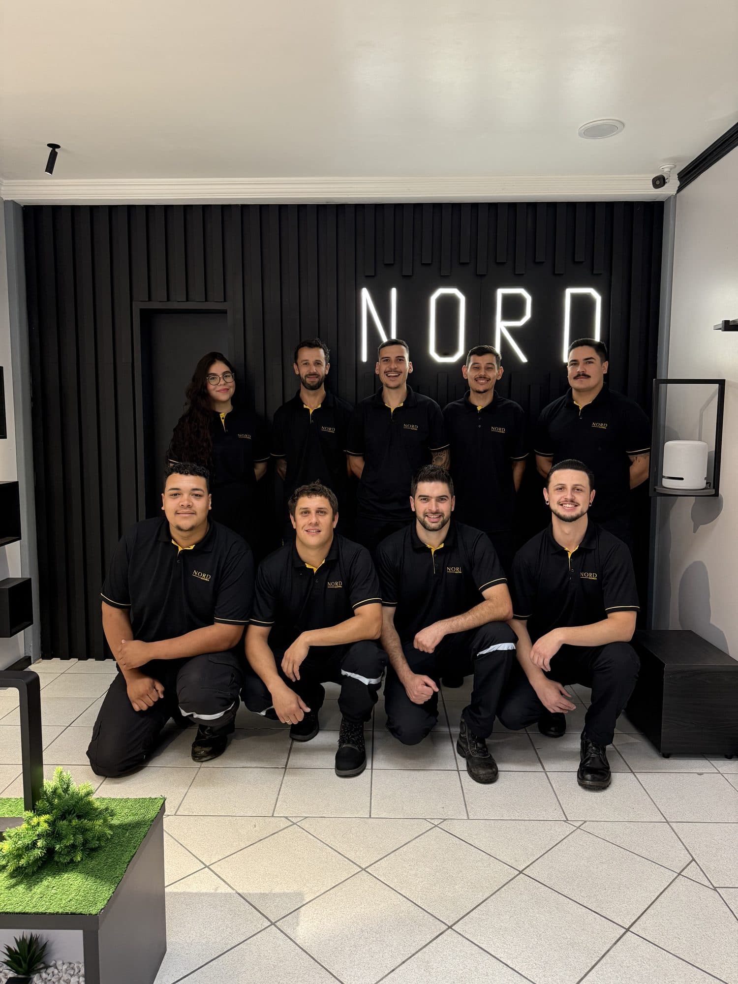 Equipe completa da Elétrica NORD em frente ao letreiro NORD